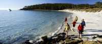Walkers on 4 Mile Beach on Maria Island