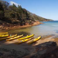 Kayaks resting on a remote Tasmanian beach | Amy Russell