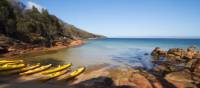 Kayaks resting on a remote Tasmanian beach | Amy Russell