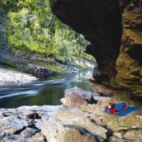 Camping under a rock shelter at Newland's Cascade on the Franklin River | Carl Roe
